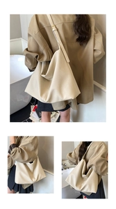 Detail view of large cream tote bag showing pebble leather texture and adjustable strap