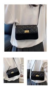 Detailed view of black quilted faux leather crossbody bag with gold metal turn-lock closure