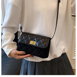 Detail der schwarzen Stepptasche mit goldenem Drehverschluss und Leder-Wildleder-Patchwork