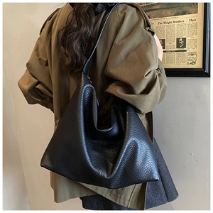 Close-up of black lychee texture leather hobo bag showing premium grain and slouchy shape