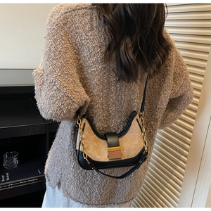 Detail of retro half-moon suede bag with gold chain strap and bicolor拼接 design