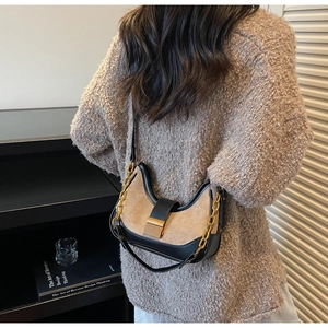 Detail of crescent suede shoulder bag with brown patchwork, gold chain and buckle