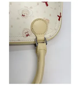 Detail of reinforced shoulder strap attachment with silver metal D-ring on printed PU bag