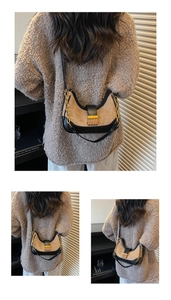 Detail of beige suede shoulder bag with black trim, gold chain, and metal lock buckle