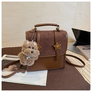 Detail of vintage brown quilted shoulder bag with star metal studs and dog pendant