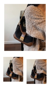 Detail of suede crossbody bag with gold chain strap and metallic rectangular buckle