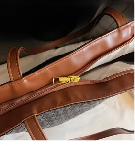 Detail of smooth gold zipper closure on minimalist woven leather tote bag with lining