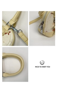 Close-up of shell bag featuring cartoon bear print, silver hardware, and stitching details