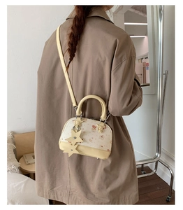 Mini shell crossbody bag with cute bear print and star charms shown on model back