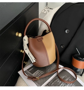 Vue détaillée du sac seau bicolore avec texture grainée et détails de sangle tendance
