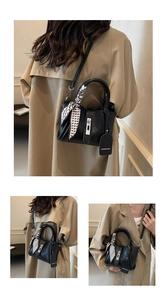 Detail of black bucket bag with houndstooth silk scarf and detachable shoulder strap