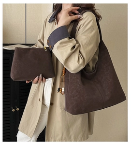 Detail view of large brown faux leather tote bag and zip pouch with wooden bead charm