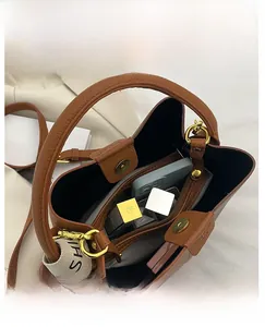 Détail intérieur d'un sac seau en cuir marron avec compartiments et fermoir magnétique