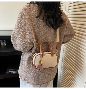 Achteraanzicht van de mini crossbodytas van canvas en leer met een brede schouderriem