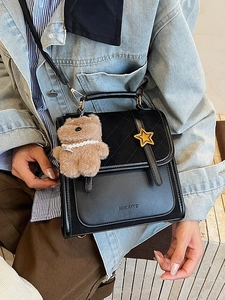 Black quilted crossbody bag for women with star metal trim and a cute plush bear charm