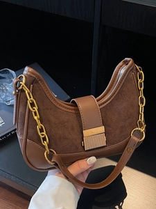 Vintage caramel suede and leather crescent bag with gold chain strap in hand