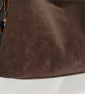 Macro shot of dark brown faux leather texture with stitching and drawstring detail