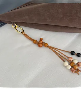 Detail of ethnic style woven wooden bead bag pendant with a golden metal spring clasp