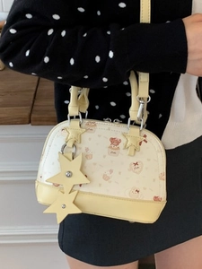 Light yellow shell-shaped PU handbag with cartoon bear print and star charm decorations