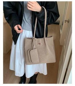 Close-up of matte khaki suede tote bag with orange embroidery and mini pouch attachment