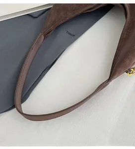 Detailed close-up of the vintage brown tote bag's leather strap and fine edge stitching