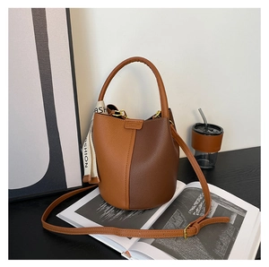 Détail du sac seau contrasté marron avec ruban tendance et bandoulière réglable