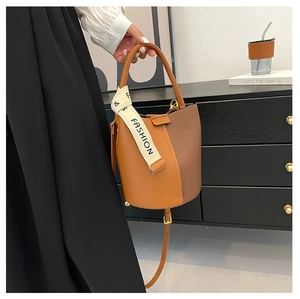 Détail du sac seau bicolore marron avec ruban décoratif et bandoulière ajustable
