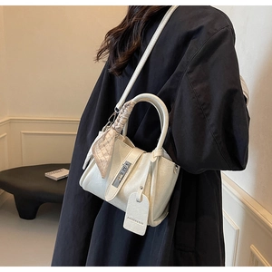 Détail du sac seau en cuir blanc crème avec poignée en foulard et fermoir métallique