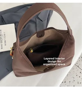 Detail showing internal compartment with zipper pocket in a brown suede tote bag