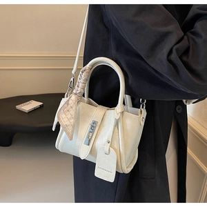 Détail du sac seau blanc cassé avec poignée en foulard de soie et fermoir argenté