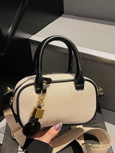 Beige canvas en zwart lederen cilindertas met brede stoffen riem en gouden slotje
