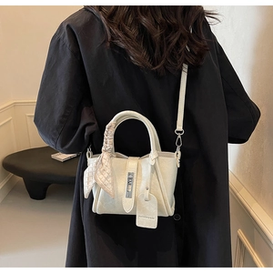 Détail du sac seau blanc crème avec foulard en soie sur la poignée et fermoir argenté