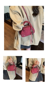 Détails du sac Boston en daim bordeaux avec clous argentés, foulard et pendentif coeur