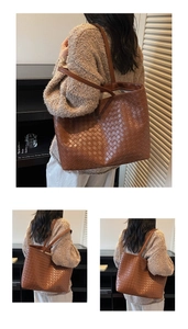 Detail of a large brown woven tote bag with a classic intrecciato texture and slim strap