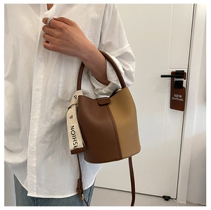 Détail du sac seau vintage en cuir grainé marron avec surpiqûres contrastées