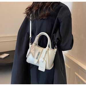 Détail du sac seau blanc cassé avec fermoir argenté et poignée en foulard de soie