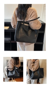 Close-up of the large woven texture and premium leather material on this black tote bag