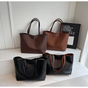 Detail view of woven leather tote bags in four colors showing the grid craft texture