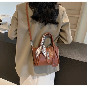 Détail du sac seau marron rétro avec poignée en foulard et étiquette de mode