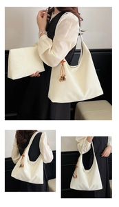 Detail of minimalist beige tote bag with wooden bead tassel and matching pouch insert