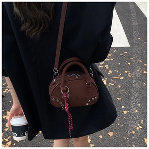 Sac bowling rétro marron givré avec rivets argentés dans un style de rue extérieur chic