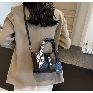 Détail du sac seau en cuir PU noir avec foulard en soie et boucle en métal argenté