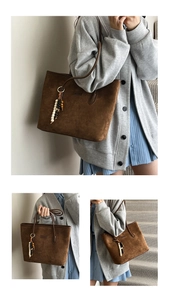 Detailed view of a brown suede tote bag featuring a vintage ethnic beaded charm accessory