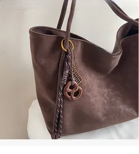 Detail of dark brown retro tote bag with unique woven rope and biscuit shaped pendants