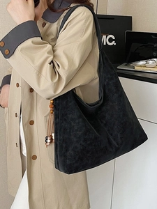 Minimalist black oversized hobo bag with ethnic charm, stylish office worker shoulder bag