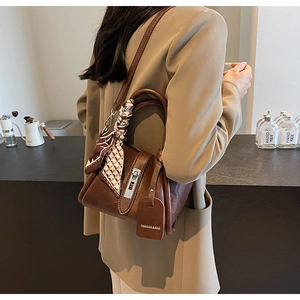 Vue latérale d'un sac seau marron en similicuir avec foulard en soie et boucle argentée