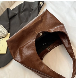 Dettaglio della borsa tote in pelle marrone scuro con texture stropicciata e fibbia