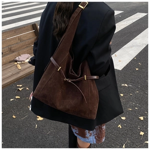Détail d'un grand sac Hobo en daim marron avec boucle dorée sur bandoulière chic