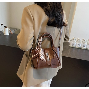 Vue détaillée du sac seau en cuir grainé marron avec foulard décoratif et bandoulière chic