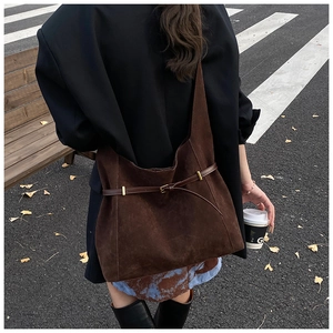 Détail du sac cabas en cuir mat marron foncé avec boucle métallique décorative